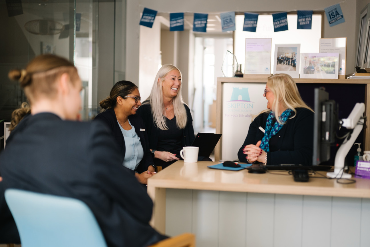 Group of branch colleagues laughing together at desk