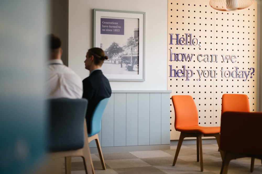 Seating area in Skipton branch with 'Hello, how can we help you today sign' in the background.