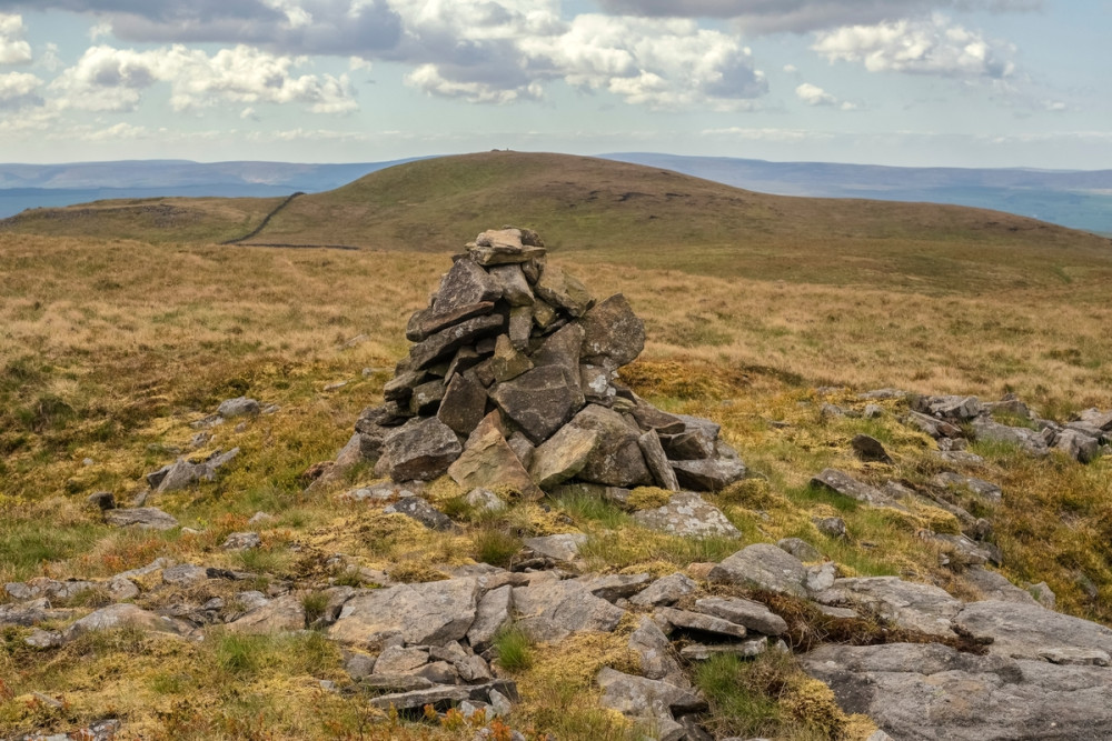 Pile of rocks in forefront of Yorkshire Dales landscape.