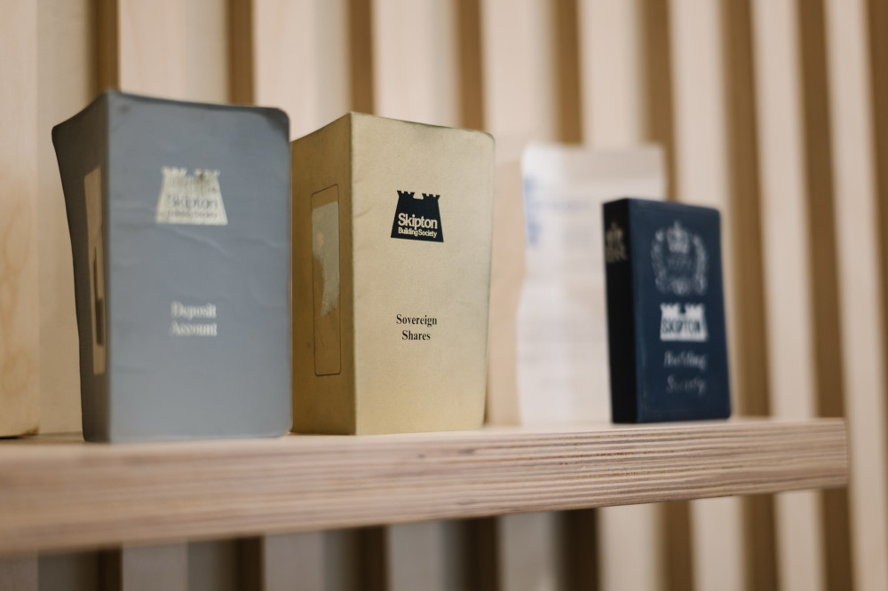 Old Skipton savings documents with 'Sovereign Shares' booklet on display in branch.