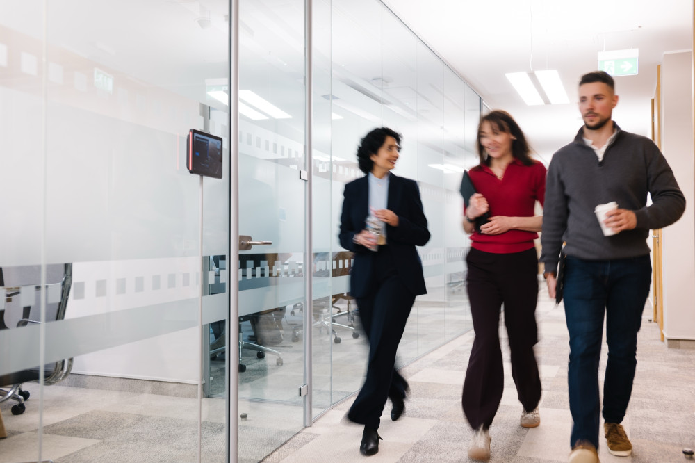 Three colleagues walking together at Skipton Head Office.