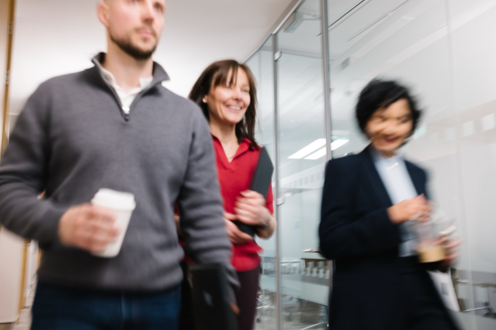 Colleagues walking together down corridor in Skipton Head Office.