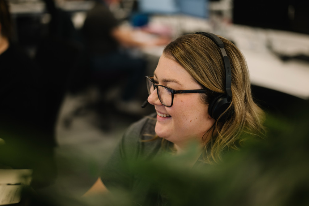 Colleague with glasses and headset on.