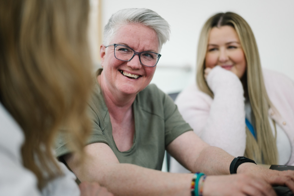Colleague smiling in team meeting.