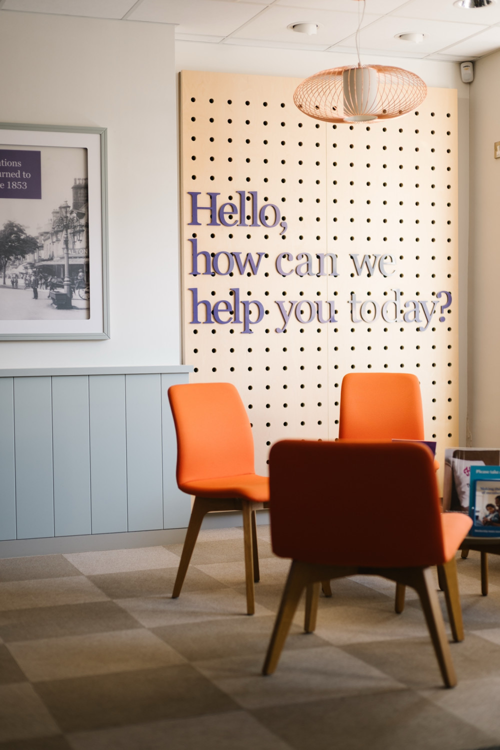 Seating area in Skipton branch with 'Hello, how can we help you today sign' in the background.
