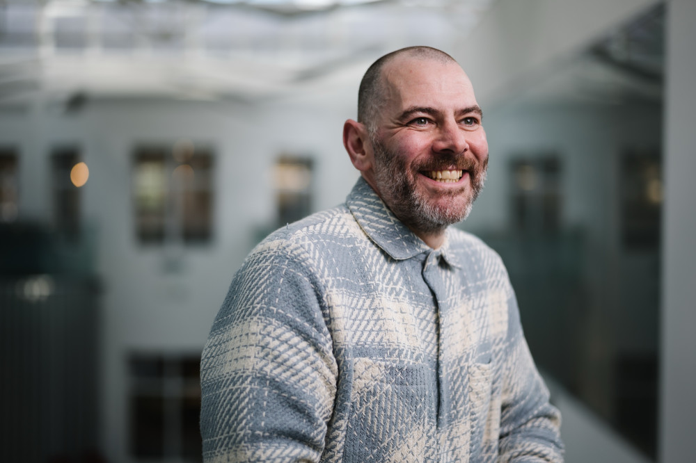 Smiling colleague in Skipton Head Office atrium.