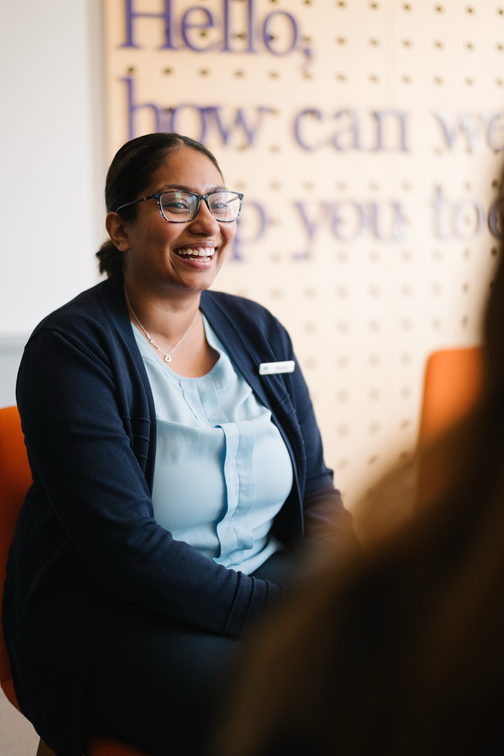 Branch colleague smiling with signage behind.