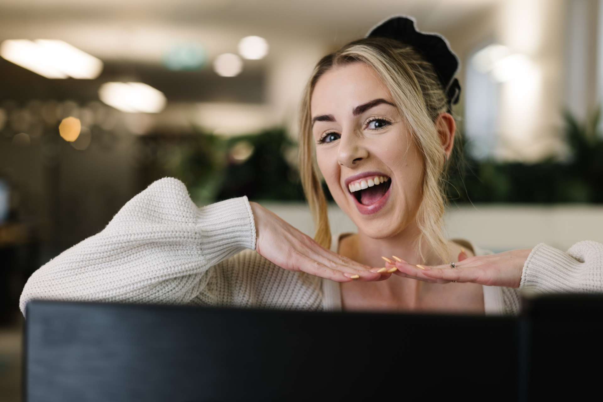 Colleague posing over computer desk in Skipton Head Office.